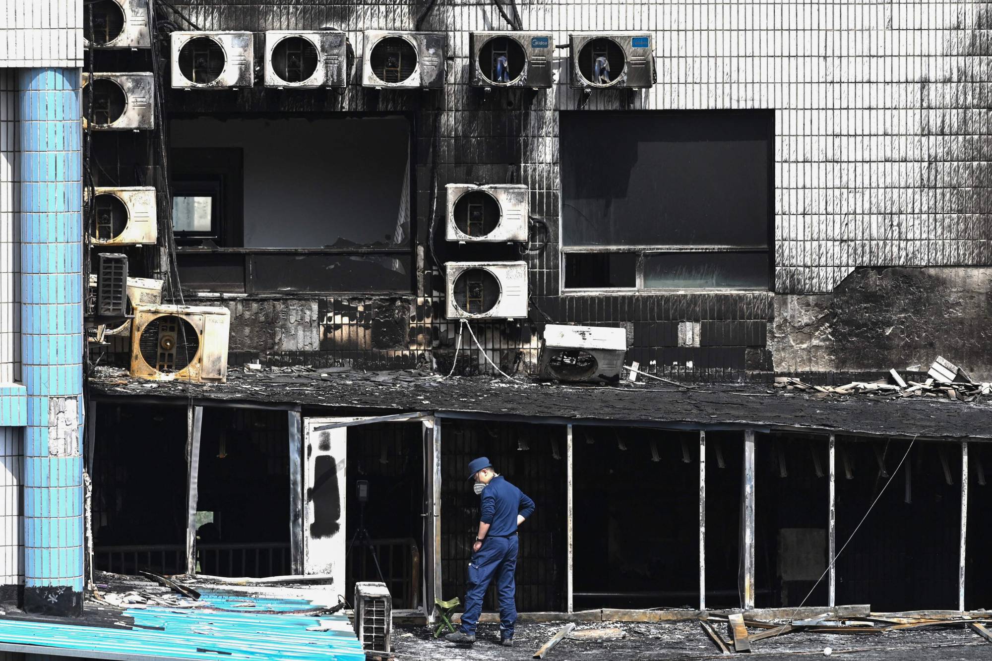 An investigator inspects the damage at the Changfeng Hospital in Beijing on Wednesday after a fire broke out the day before.  | AFP-JIJI