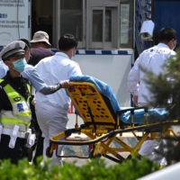 Workers bring a gurney into the Changfeng Hospital in Beijing on Wednesday after a fire broke out a day earlier.  | AFP-JIJI