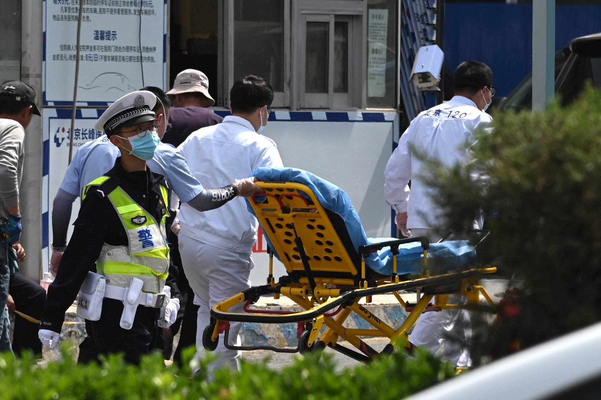 Workers bring a gurney into the Changfeng Hospital in Beijing on Wednesday after a fire broke out a day earlier.  | AFP-JIJI