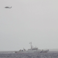 Japan maritime forces conduct a search mission after a Japan Ground Self-Defense Force helicopter with 10 people on board disappeared from radar on April 6 in islands near Okinawa. | JAPAN COAST GUARD / VIA AFP-JIJI