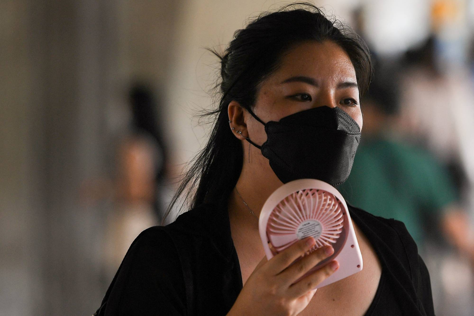A woman uses a hand fan as temperatures soared in Bangkok on Saturday. | reuters