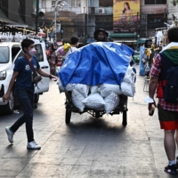 A vendor pushes a cart of bagged ice on Khao San Road in Bangkok on Thursday amid a heat wave.  | AFP-JIJI