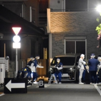 Investigators outside a home in Hino, western Tokyo, where two women were allegedly attacked by their brother with an ax | KYODO 