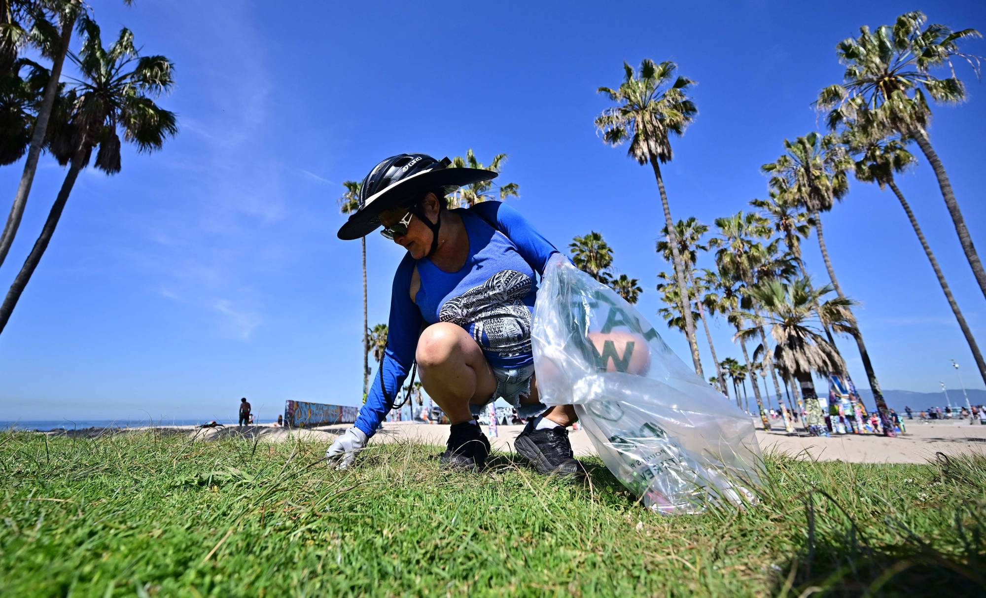 A volunteer cleans up trash at Venice Beach in Los Angeles on Saturday for Earth Day. | AFP-JIJI