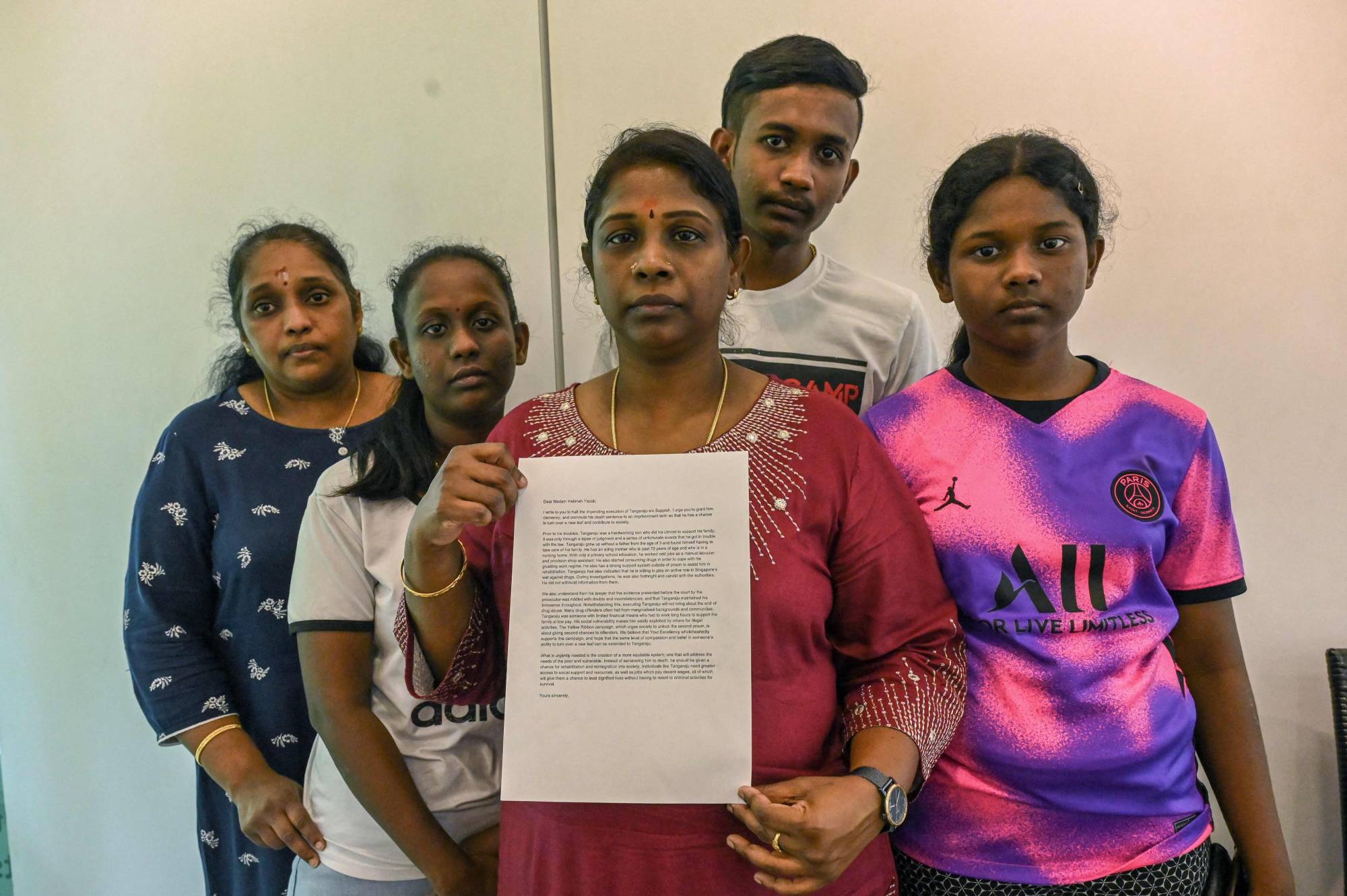 Family members of Tangaraju Suppiah, who is scheduled for execution in Singapore after being convicted of drug trafficking, show off a petition letter seeking clemency, on Sunday. | AFP-JIJI