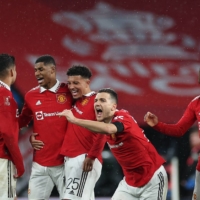 Manchester United players celebrate after winning a penalty shootout against Brighton during the FA Cup semifinals in London on Sunday. | AFP-JIJI