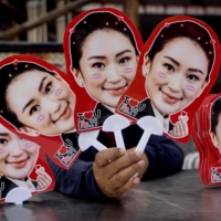 A woman holds up placards featuring Thai candidate for prime minister Paetongtarn Shinawatra at the Thunder Dome Stadium in Nonthaburi, north of the capital Bangkok | AFP-JIJI