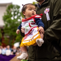 A parent holds his child before the \"Baby-cry Sumo\" match at Sensoji temple in Tokyo on Saturday | AFP-JIJI