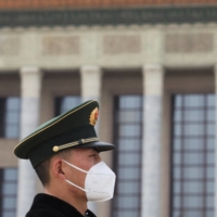 A paramilitary police officer outside the Great Hall of the People in Beijing in March | REUTERS