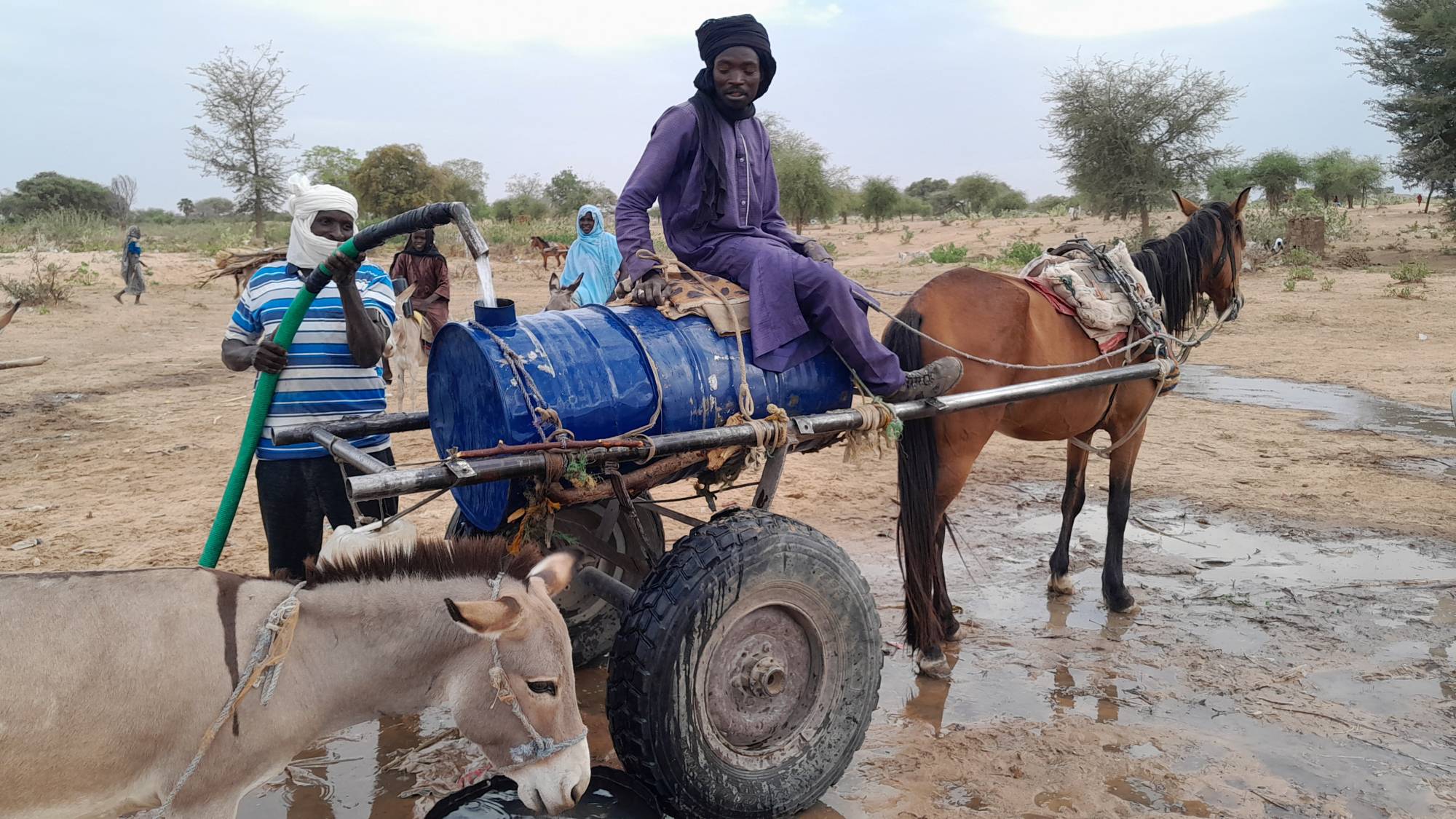 Mahamat Bechir Abdallah, a Sudanese refugee, fills a container as he sells water to the other refugees near the border between Sudan and Chad, in Koufroun, Chad, on Monday. | REUTERS