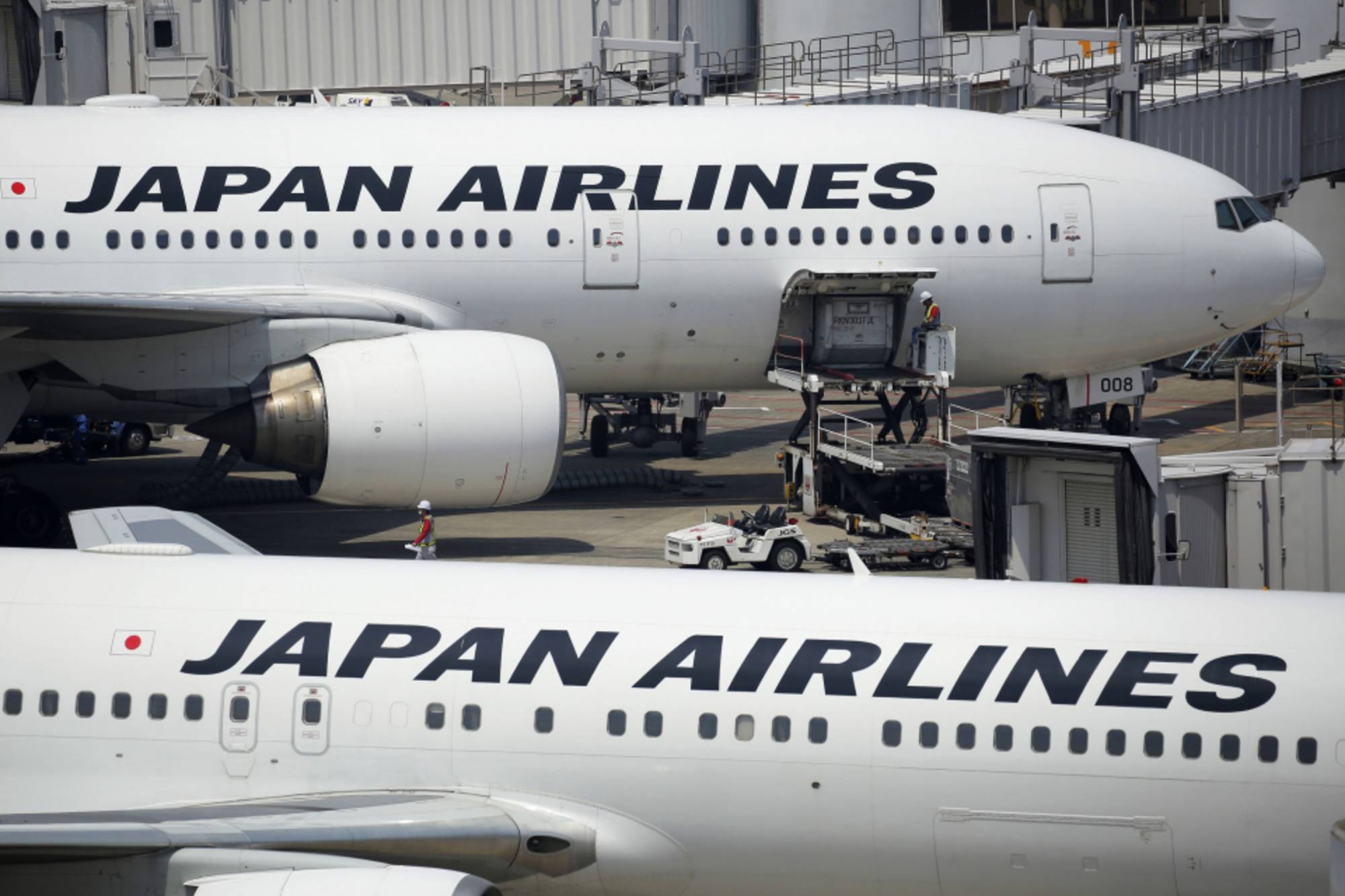 Cargo is loaded onto a Japan Airlines aircraft at Haneda Airport in Tokyo. JAL plans to introduce three new dedicated cargo planes this fiscal year to meet increasing demand in the international e-commerce industry. | BLOOMBERG
