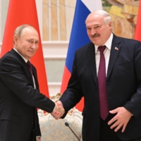 Russian President Vladimir Putin shakes hands with Belarusian President Alexander Lukashenko during a news conference in Minsk, Belarus, on Dec. 19. Putin has expressed his intention to help build the nuclear delivery capabilities of the Belarusian military. | SPUTNIK / KREMLIN / VIA REUTERS