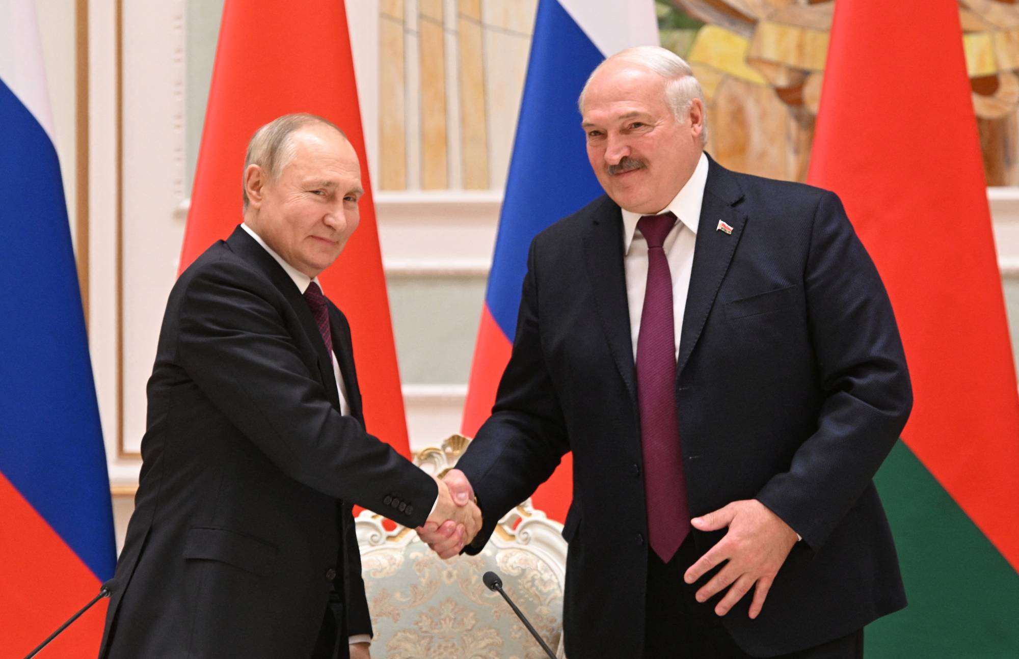 Russian President Vladimir Putin shakes hands with Belarusian President Alexander Lukashenko during a news conference in Minsk, Belarus, on Dec. 19. Putin has expressed his intention to help build the nuclear delivery capabilities of the Belarusian military. | Sputnik / Kremlin / via REUTERS