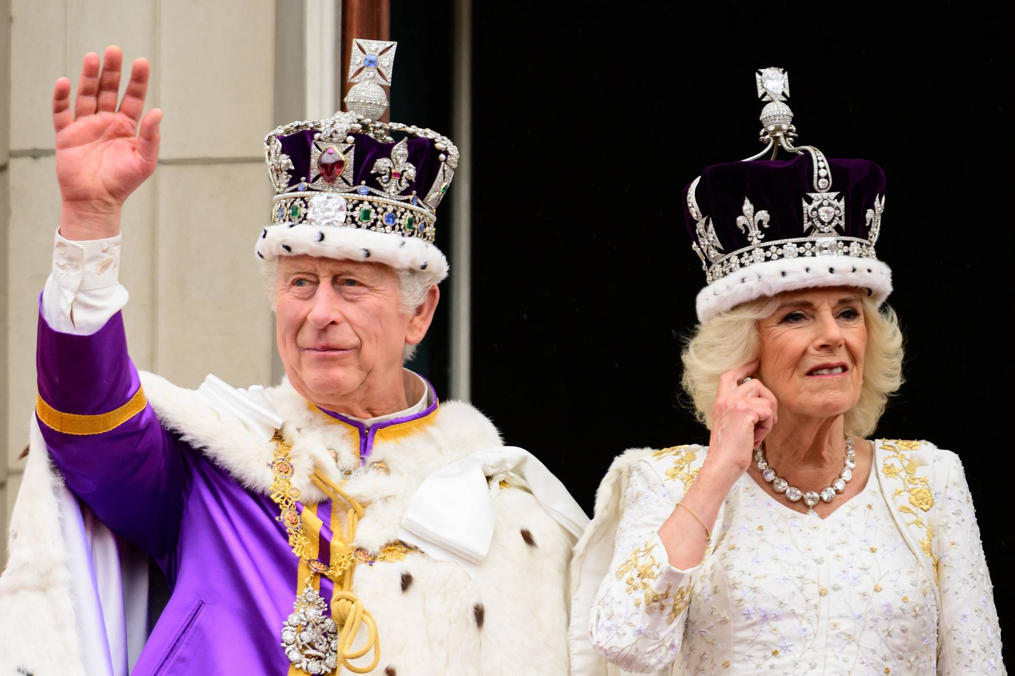 Britain's King Charles III and Queen Camilla wave from the Buckingham Palace balcony in London, following their coronations on Saturday. | POOL / VIA AFP-JIJI