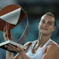 Aryna Sabalenka poses with the winner\'s trophy after beating Iga Swiatek in the final of the Madrid Open on Saturday. | AFP-JIJI