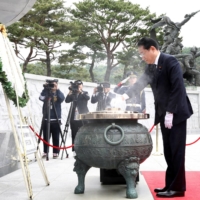 Prime Minister Fumio Kishida burns incense as his wife, Yuko, looks on during a visit to Seoul National Cemetery in the South Korean capital, on Sunday. Kishida was set to hold a meeting with South Korean President Yoon Suk-yeol later in the day.  | POOL / VIA REUTERS