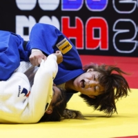Natsumi Tsunoda (in blue) and France\'s Shirine Boukli compete in the women\'s 48-kilogram final at the world judo championships in Doha on Sunday. | KYODO