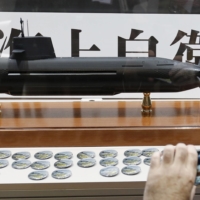 A visitor takes a picture of a model of the Maritime Self-Defense Force\'s Soryu diesel-electric submarine at the MAST Asia defense exhibition and conference in Yokohama in May 2015. | REUTERS