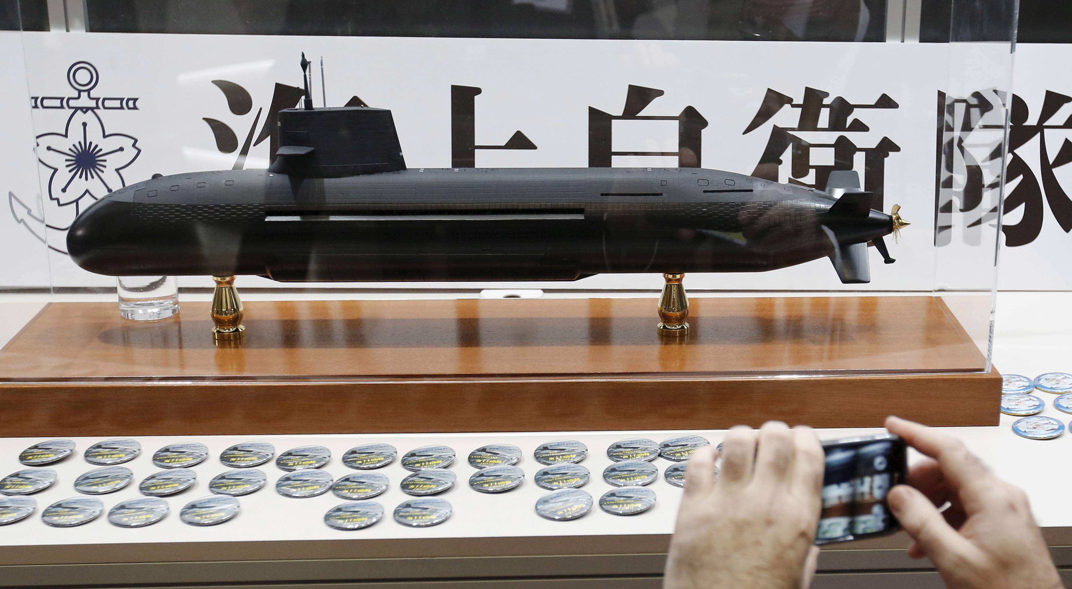 A visitor takes a picture of a model of the Maritime Self-Defense Force's Soryu diesel-electric submarine at the MAST Asia defense exhibition and conference in Yokohama in May 2015. | REUTERS