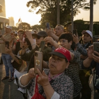 Mainland Chinese tourists at the Golden Bauhinia Square in the Wan Chai district in Hong Kong in April. The return to Hong Kong of budget tour groups from mainland China is sparking frustrations, and a dose of snobbery, in a city starved for business. | ANTHONY KWAN / THE NEW YORK TIMES