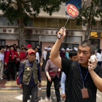 A guide leads a group of mainland Chinese tourists outside an eatery in the To Kwa Wan neighborhood of Hong Kong. | ANTHONY KWAN / THE NEW YORK TIMES