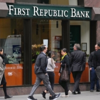 People pause to read and photograph a press release from the Federal Deposit Insurance Corporation taped to the window at the headquarters of First Republic Bank in San Francisco on May 1. Due to the collapse of the bank earlier this month, Group of Seven finance ministers and central bank governors are likely to try and build consensus around key issues relating to the global financial system. | JIM WILSON / THE NEW YORK TIMES)