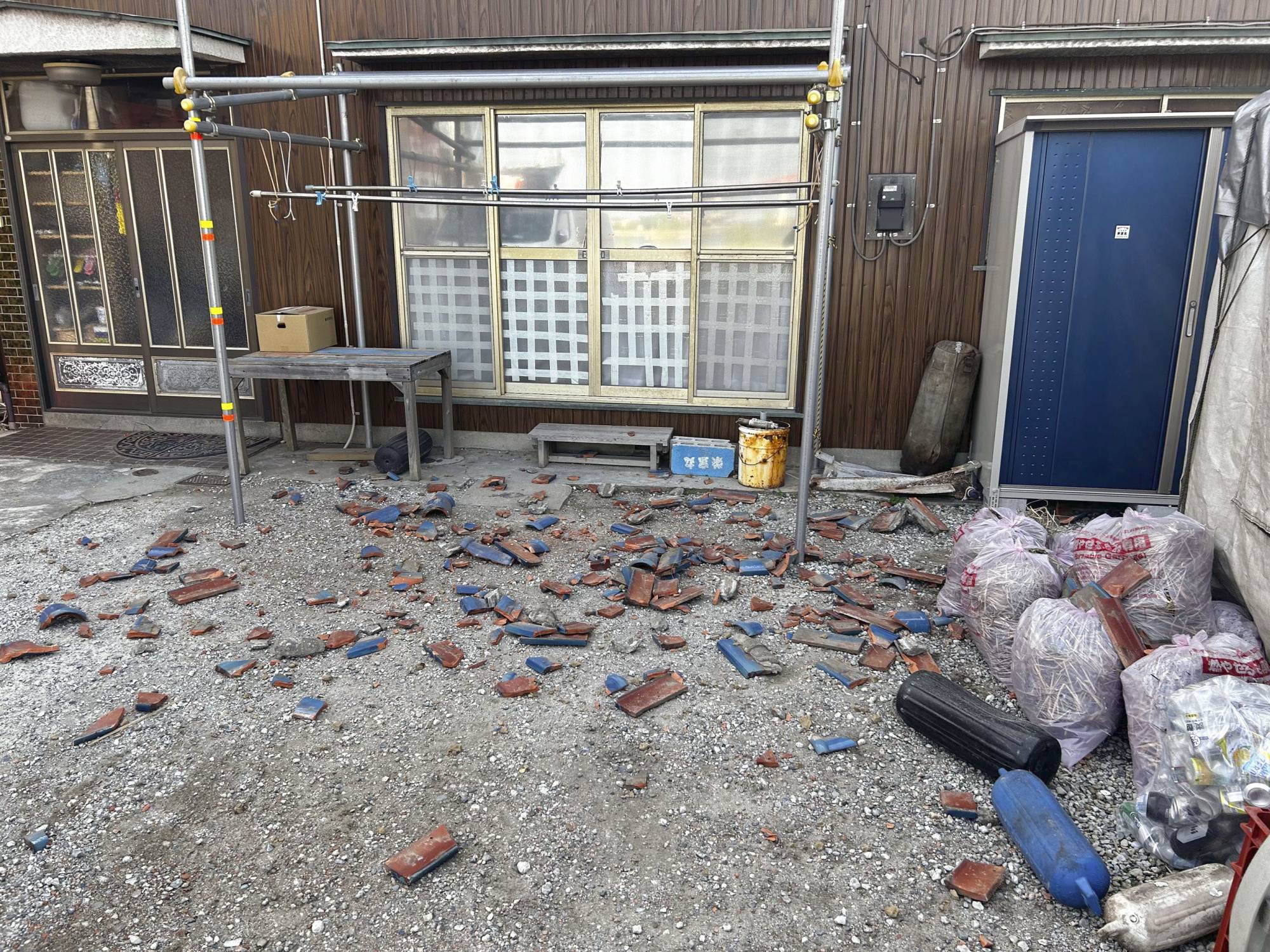 Fallen roof tiles are scattered on the ground outside a house in Kisarazu, Chiba Prefecture, after a powerful quake hit eastern Japan on Thursday morning. | KYODO