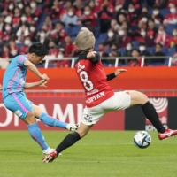 Sagan Tosu\'s Kohei Tezuka (center) shoots and scores his team\'s second goal in their 2-0 J. League victory over Urawa Reds at Saitama Stadium on Wednesday. | KYODO