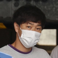 Kosuke Omoto is taken from a police station in Tokyo to be sent to prosecutors on Thursday. | KYODO