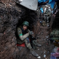 Ukrainian servicemen rest at their positions after a fight, as Russia\'s attack on Ukraine continues, near the front line city of Bakhmut, in Ukraine\'s Donetsk region, on Thursday.  | RADIO FREE EUROPE / RADIO LIBERTY / VIA REUTERS     