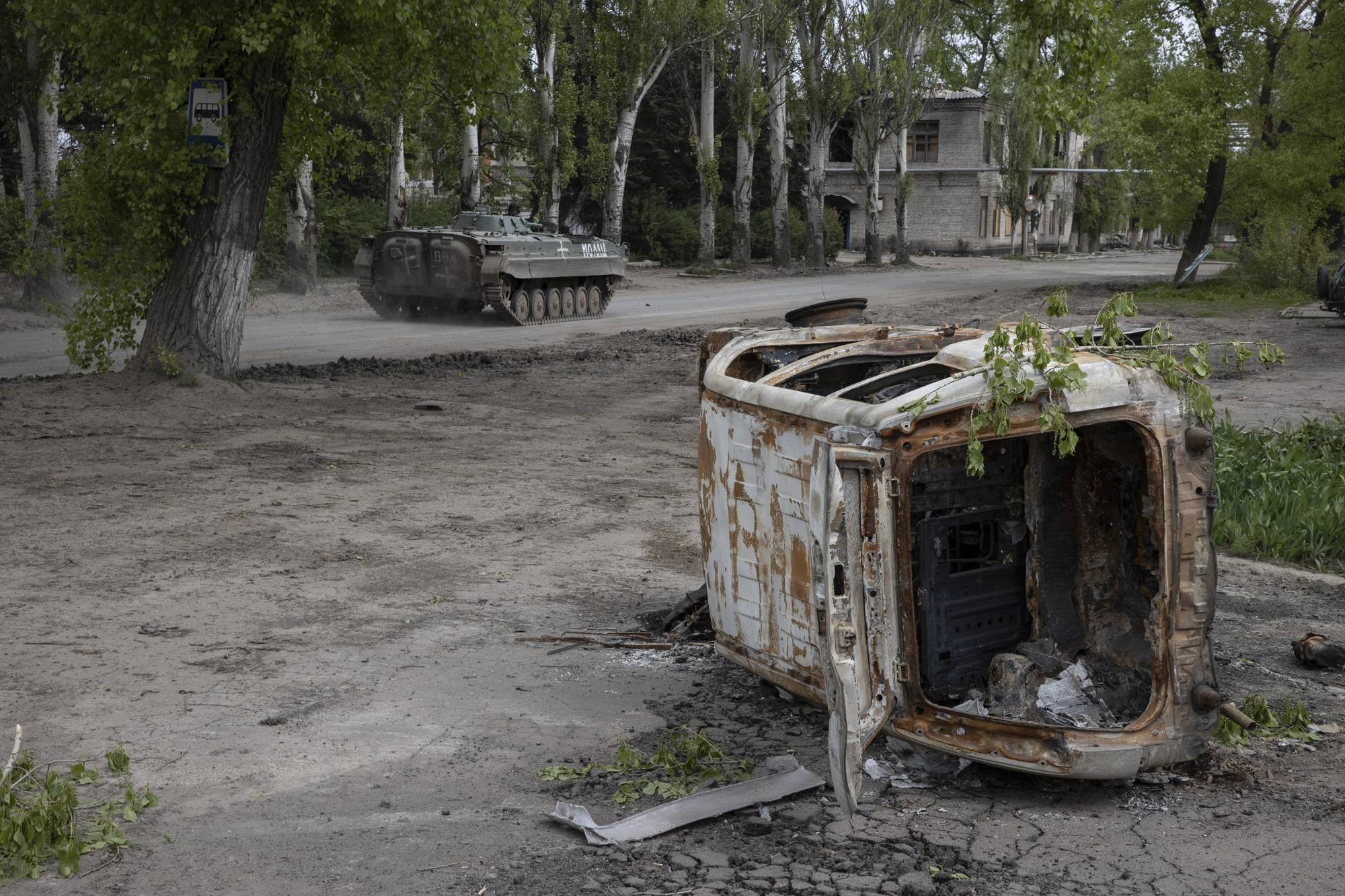 A Ukrainian BMP infantry fighting vehicle passes a destroyed car in Chasiv Yar, a small town west of Bakhmut, Ukraine, on Tuesday. | Tyler Hicks / The New York Times