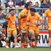 Tokyo Bay\'s Yota Kamimori (second from right) celebrates after scoring a first-half try against Sungoliath at Prince Chichibu Memorial Rugby Ground on Sunday. | KYODO
