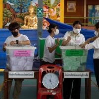 Electoral officials prepare for preliminary counting of votes at a polling station in the Phrom Phong area of Bangkok on Sunday. | BLOOMBERG