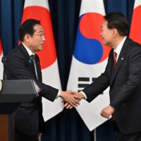 Prime Minister Fumio Kishida greets South Korean President Yoon Suk-yeol during a joint news conference after their meeting at the Presidential Office in Seoul on May 7. | POOL / VIA REUTERS
