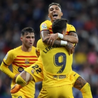 Barcelona\'s Raphinha (rear) hugs Robert Lewandowski during their league-clinching victory over Espanyol in Cornella de Llobregat, Spain, on Sunday. | AFP-JIJI