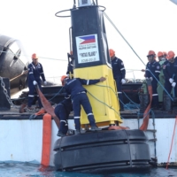Philippine Coast Guard members set navigational buoys in the Philippines\' exclusive economic zone in the South China Sea in this image released Monday.  | PHILIPPINE COAST GUARD / VIA REUTERS    