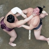 Nishikifuji (left) shoves Shodai during their Day 3 bout at Ryogoku Kokugikan on Tuesday. | KYODO