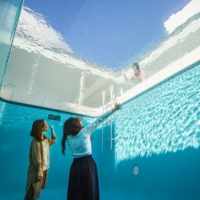 Visitors gaze up from “The Swimming Pool” by Leandro Erlich at the 21st Century Museum of Contemporary Art, Kanazawa.