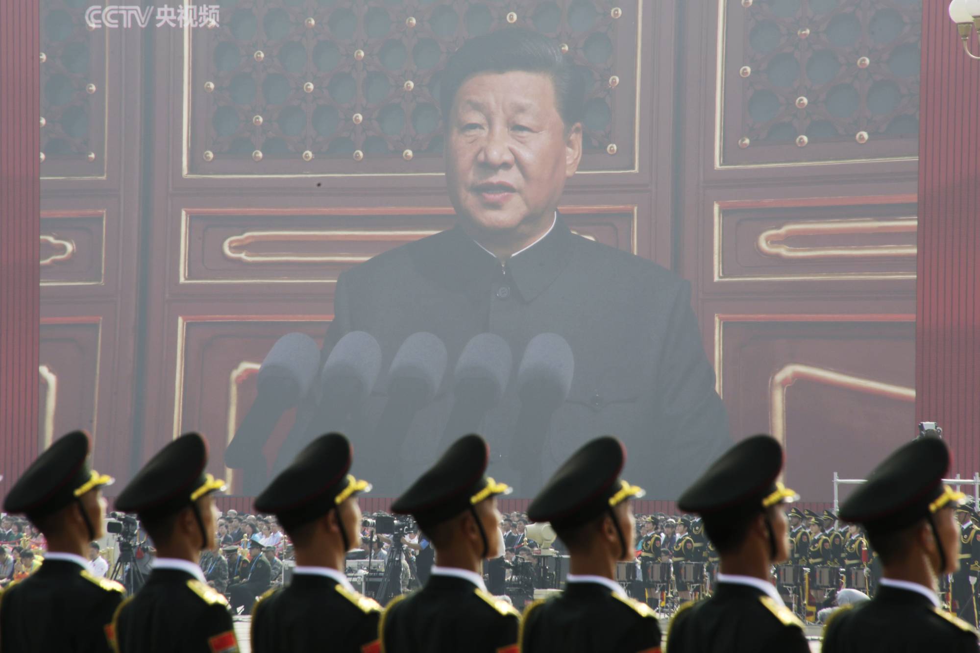 Chinese People's Liberation Army soldiers are seen before a giant screen as leader Xi Jinping speaks at the military parade marking the 70th founding anniversary of People's Republic of China, on its National Day in Beijing, on Oct. 1, 2019. | REUTERS