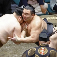 Asanoyama (right) attacks Tamawashi during their Day 4 bout at Ryogoku Kokugikan on Wednesday. | KYODO