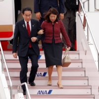 Prime Minister Fumio Kishida arrives at Hiroshima Airport on Thursday alongside his wife, Yuko, ahead of the G7 leaders summit.  | REUTERS