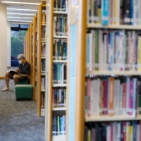 A man reads a book at Hong Kong Central Library after democracy activists\' books were taken down due to a national security law in July 2020.  | REUTERS