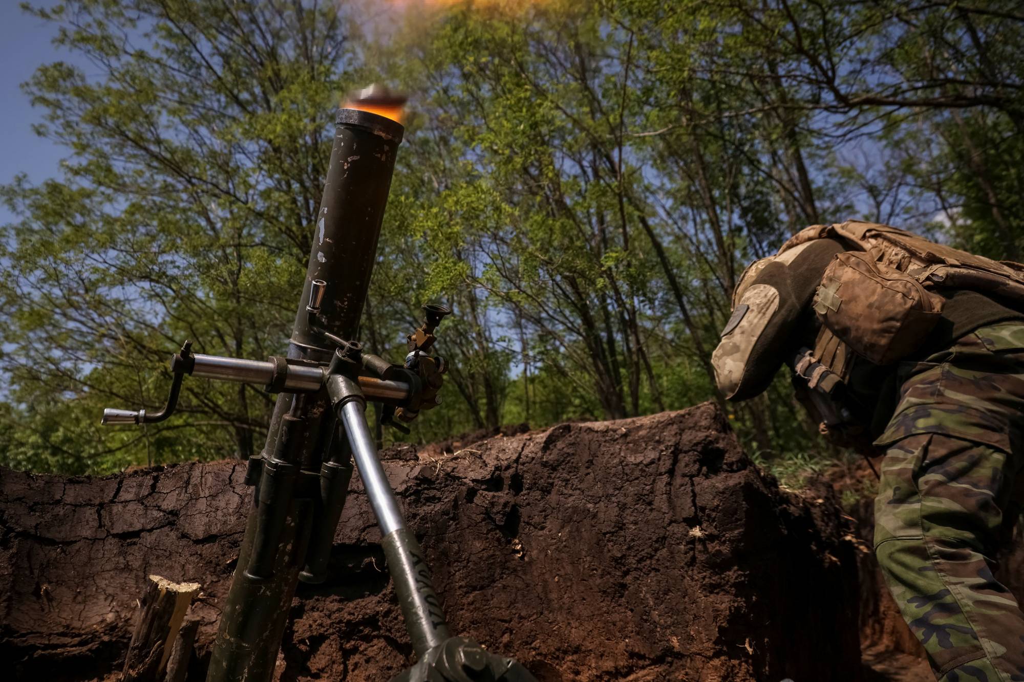 A Ukrainian service member from a 28th separate mechanized brigade fires a mortar at his position at a front line near the city of Bakhmut in the Donetsk region, Ukraine, on Thursday. | REUTERS
