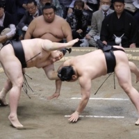 Abi (left) defeats Wakamotoharu to win their bout on Day 6 of the Summer Grand Sumo Tournament on Friday. | KYODO