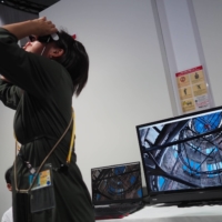 A Japan Times reporter tries an immersive virtual reality experience showing the inside of the Atomic Bomb Dome in Hiroshima, at the international media center for the Group of Seven summit in the city on Friday. | DANIEL TRAYLOR
