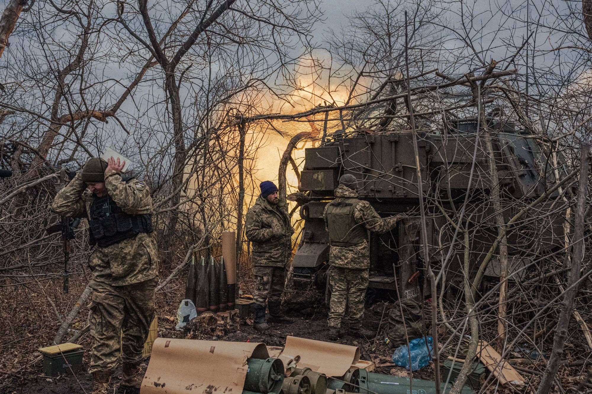 Ukrainian soldiers fire artillery rounds toward a Russian infantry position near Bakhmut, Ukraine, on March 3.  | DANIEL BEREHULAK / THE NEW YORK TIMES