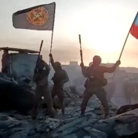 A video grab from handout footage posted Saturday on the Telegram account of the Concord press service, a company linked to the chief of the Wagner mercenary group, appears to show members of the group waving the Russian and Wagner Group flags on a building in Bakhmut.  | TELEGRAM CHANNEL OF CONCORD GROUP / VIA AFP-JIJI