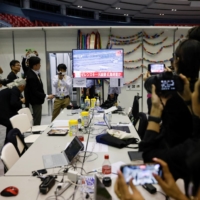 Journalists at the Group of Seven summit media center watch a live report about Zelenskyy\'s arrival in Hiroshima on Saturday. | REUTERS 