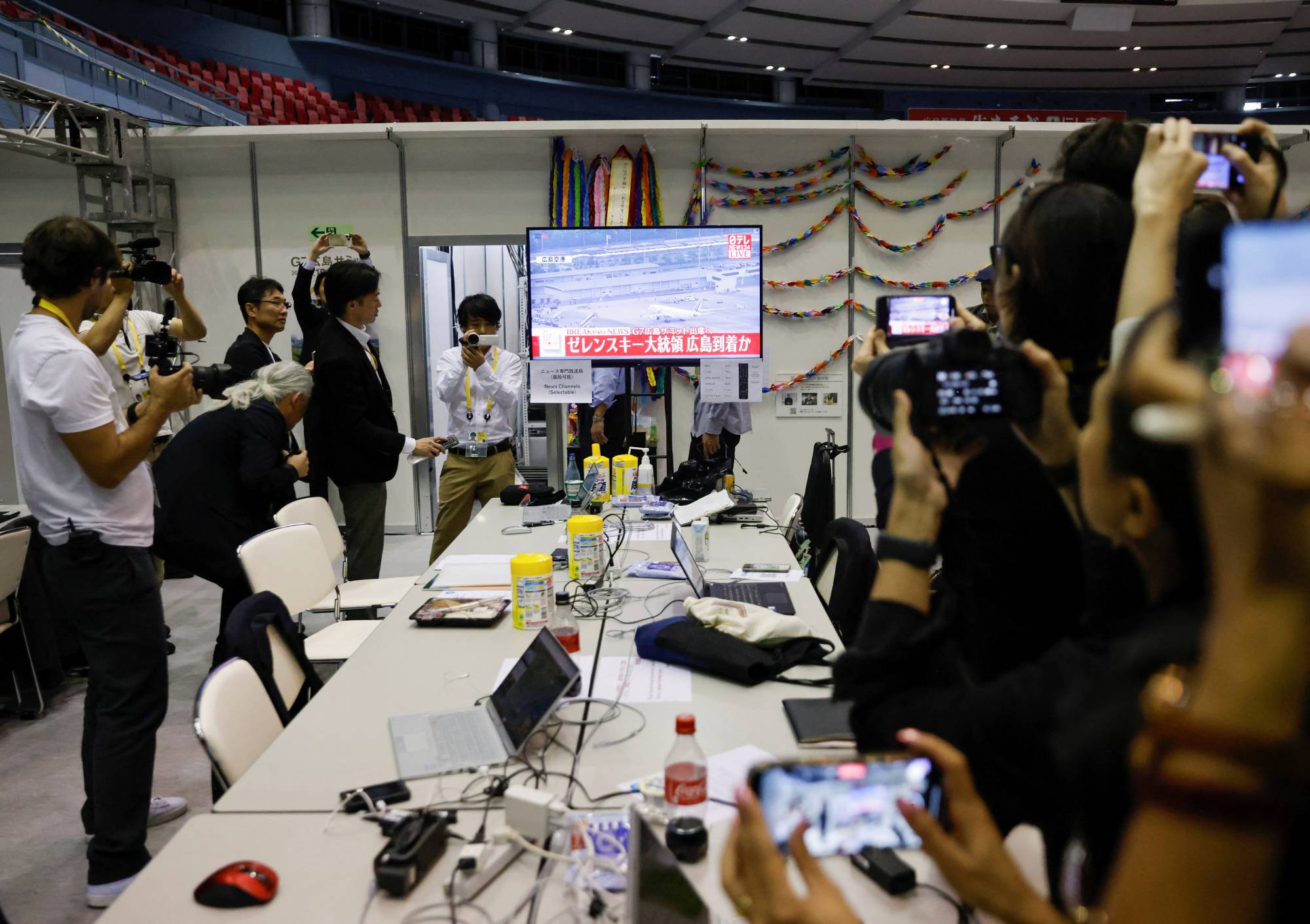 Journalists at the Group of Seven summit media center watch a live report about Zelenskyy's arrival in Hiroshima on Saturday. | Reuters 
