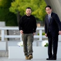 Zelenskyy is escorted by Prime Minister Fumio Kishida after laying flowers in front of the Cenotaph for the Victims of the Atomic Bomb at the Hiroshima Peace Memorial Park on Sunday.  | POOL / VIA REUTERS 
